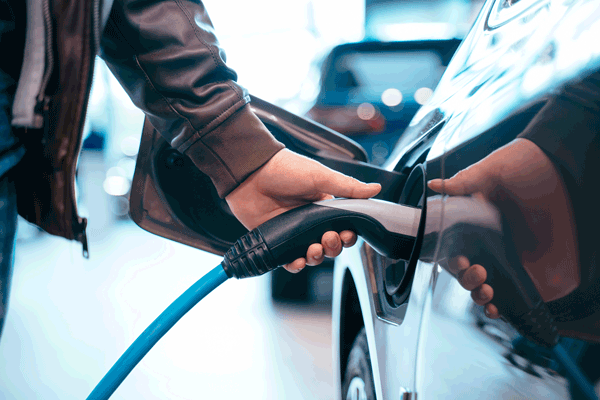 Una persona carga su coche híbrido o eléctrico